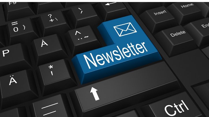 A black computer keyboard with a blue return key that has a picture of an envelope on it with the text Newsletter