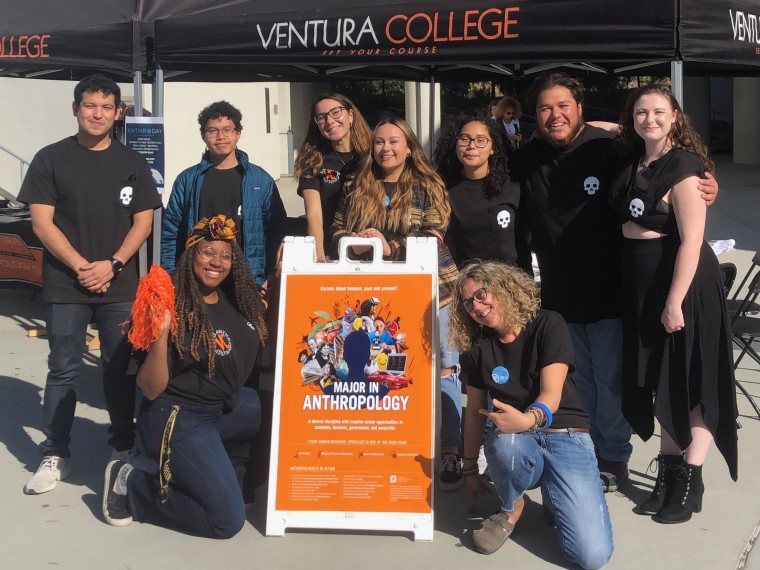 Anthropology club members with advisor in front of tent booth at club tabling event