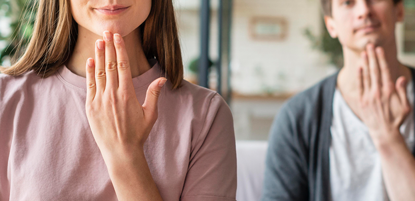Front view of couple communicating with sign language.