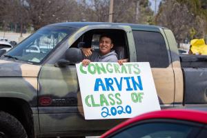 Drive thru graduation at Oxnard College, student holding a s Drive thru graduation at Oxnard College, student holding a s